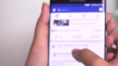 Closeup smartphone touching sliding Facebook news feed page woman hand finger 4K Stock Footage 77741705