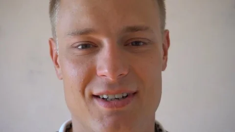 Closeup of smiling young man looking at camera isolated on white background Stock Footage 79194101