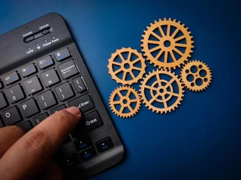 Closeup someone use black keyboard with wooden gear on a blue background. B.. Stock Photos