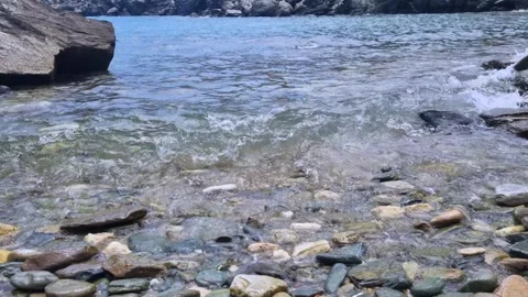 Closeup of sparkling clear shallow waters and a small wave lapping against .. Stock Footage 318216142