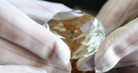 Closeup of sparkling large round diamond in expert hand showing play of edges in Video stock 233020046