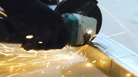 Closeup of sparks from circular grinding machine cutting metal profile in Stock Footage 91952259