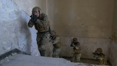 Closeup of special forces team moving up the stairs in abandoned building in  Stock Footage 78032927