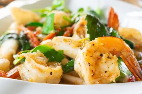 Closeup of Spicy fried seafood with shrimp in white dish. Stock Photos
