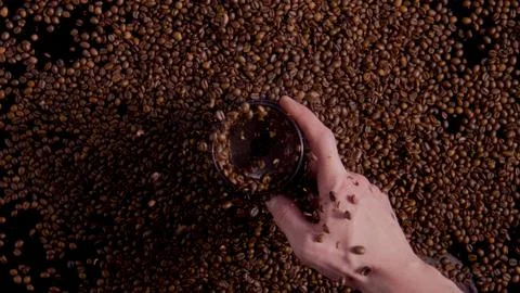 Closeup spinning coffee grinder with exploded grains in barista hand top view. Stock Photos