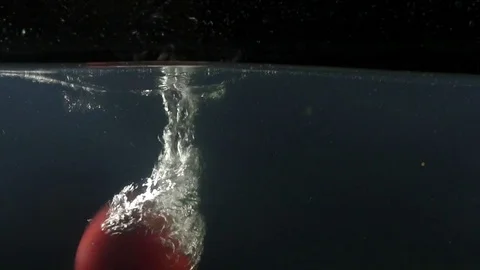 Closeup of spinning tasty apple falling into water on the black backgrond slow Stock Footage 75790646