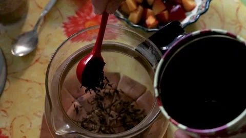 Closeup of a spoon scooping loose tea leaves from metal tin and adding them.. Stock Footage 340917169