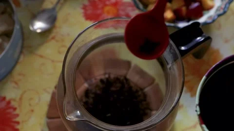 Closeup of a spoon scooping loose tea leaves from metal tin and adding them.. Stock Footage 340917178
