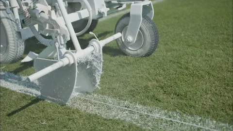 Closeup of spray paint machine spraying line on football field Stock Footage 105424166