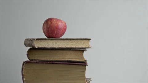 Closeup of stack of books and red apple rotating. Copy space Stock Footage 71900680