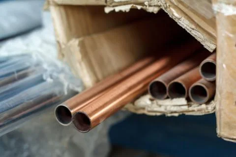 Closeup of a stack of copper pipes for water and heating systems, soft focus Stock Photos