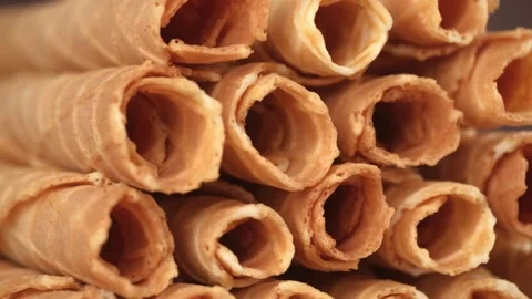 Closeup stack of hollow waffle tubes rotates. waffle rolls, delicious dessert. Stock Footage 241331703