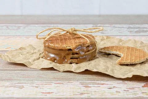 Closeup of a stack of stroopwafels on a brown paper, next to another biscuit  Stock Photos