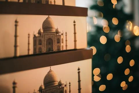 A closeup of stacked boxes printed with the Taj Majal mausoleum and bokeh lig Stock Photos