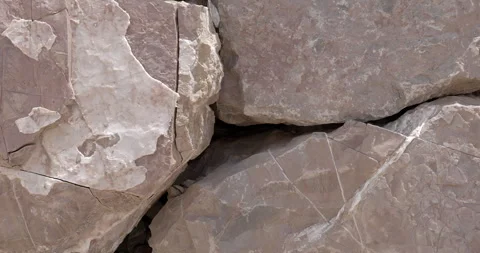 Closeup of stacked worn rocks of all pattern and texture in bright light Stock Footage 314345028