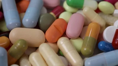 Closeup static seamless loop of rotating pile of colorful pills Stock Footage 286218900