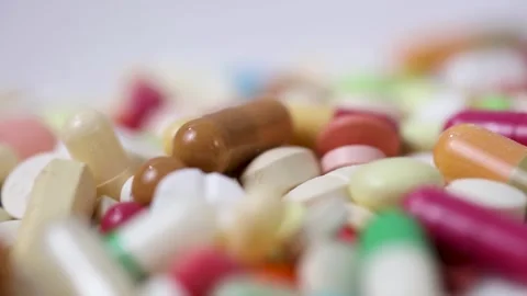 Closeup static shot of rotating pile of colourful medicine pills Stock Footage 280677576