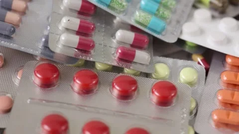 Closeup static shot of rotating pile of pills in blisters Stock Footage 288107093