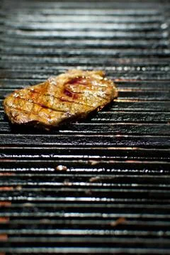 Closeup of a steak on a grill Stock Photos