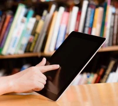 Closeup stedent using tablet computer in library Stock Photos