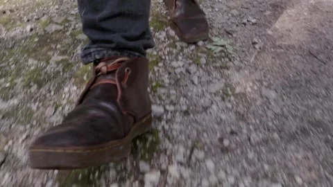 Closeup of steps in the woods with brown boots while walking Stock Footage 253132231