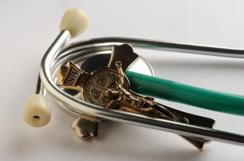 Closeup on stethoscope with crucifix Stock Photos