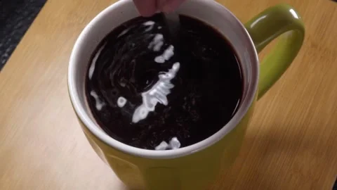 Closeup of Stirring Fresh Coffee in Ceramic Mug Creating Dark Swirling Surface Video stock 340805987