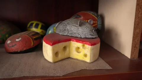 Closeup of a stone painted in the shape of cheese with a mouse on it Stock Footage 140393837