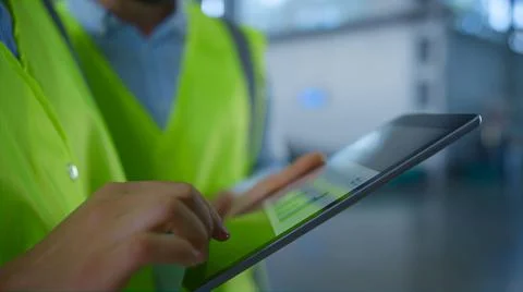 Closeup storage workers tablet data checking manufacture inspection process. Stock Photos