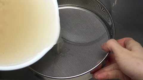 Closeup of straining Quinoa water with filter in sink. Cooking superfood. 4K Stock Footage 168348234