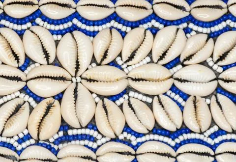 Closeup of a stringed white and blue strings and cowrie shells forming a pattern Stock Photos