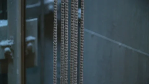 Closeup: Strong suspended cables inside elevator shaft move, carrying the car Stock Footage 99262398