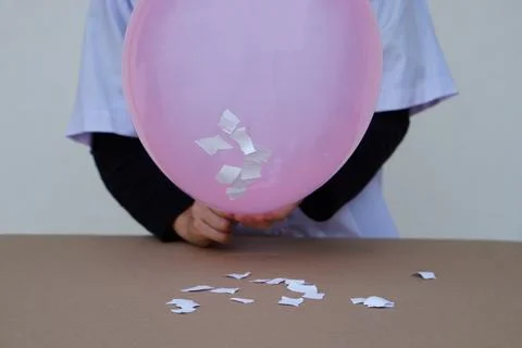 Closeup student do science experiment about static electricty from pink balloon Stock Photos
