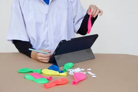 Closeup student writes on smart tablet during studying about static electricity Stock Photos