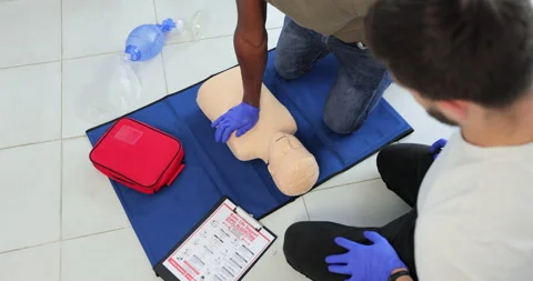 Closeup of students practicing CPR chest compression on teen dummy. Stock Footage 163979693