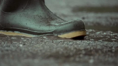 A closeup of stylish boots splashing through puddles on a rainy day Stock Footage 313283594