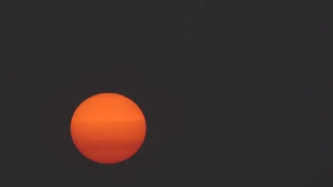 Closeup of sun rising through hazy sky Stock Footage 139781040