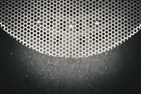 Closeup of a surface with a pattern of circular holes in a metal grille or... Fotos de archivo