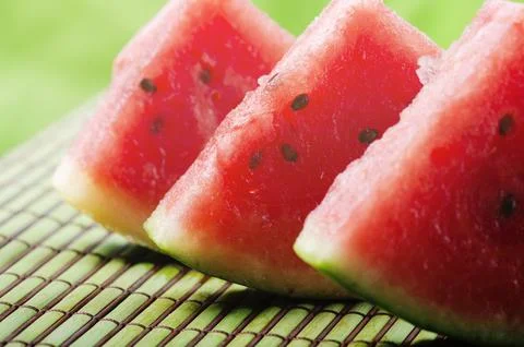 Closeup of sweet red watermelon slices on green table background in garden .. 스톡 사진