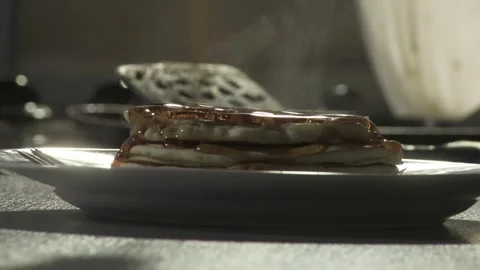Closeup syrup being poured onto stack of steaming pancakes Stock Footage 282232108