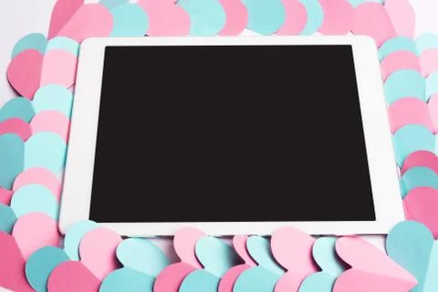 Closeup of tablet computer framed with paper hearts Stock Photos