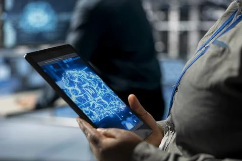 Closeup of tablet used by data center computer scientist to upgrade AI workloads 스톡 사진