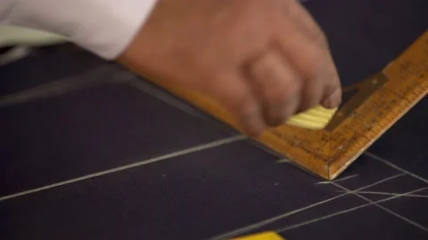 Closeup of tailor's hand putting marks on clothes using the right angle scale Stock Footage 163191549