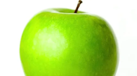 Closeup of tap water falling down on succulent green apple fruit against whit Stock Footage 62714494