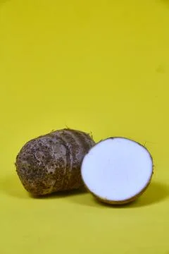 Closeup of taro root vegetable, eddo malanga, yellow background Stock Photos