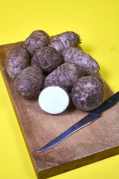 Closeup of taro root vegetable, eddo malanga, yellow background Stock Photos