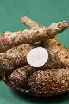 Closeup of taro root vegetable, eddo malanga, green background Foto stock