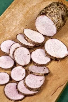 Closeup of taro root vegetable, eddo malanga, green background Stock Photos