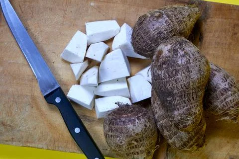 Closeup of taro root vegetable, eddo malanga, yellow background Stock Photos