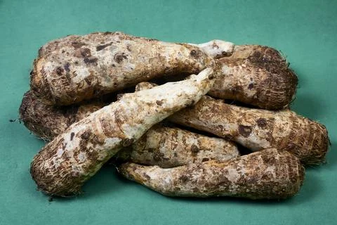 Closeup of taro root vegetable, eddo malanga, green background Stock Photos